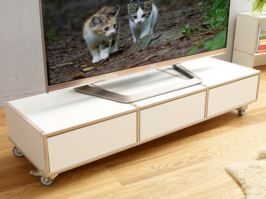 Weißes TV-Board aus Birken-Holz auf Rollen mit Schubladen.